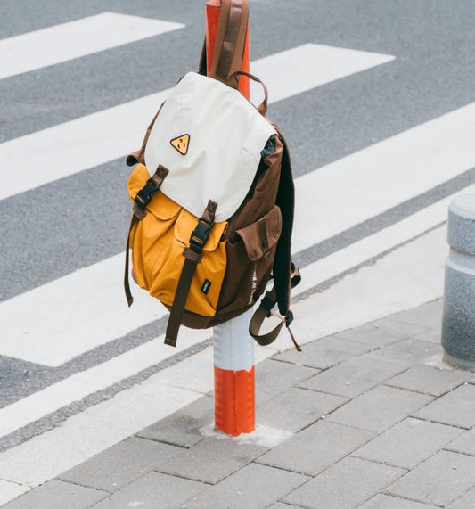 7706 artist backpack hanging on street post with creative supplies visible, urban artistic lifestyle