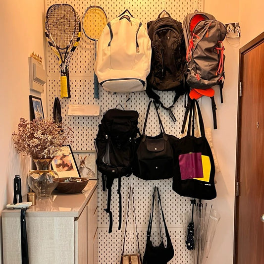 Fully organized pegboard wall storage system displaying multiple backpacks, sports bags, and equipment demonstrating effective backpack storage solutions