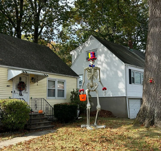Halloween decorated house with skeleton holding orange trick-or-treat bag perfect for Halloween gift inspiration
