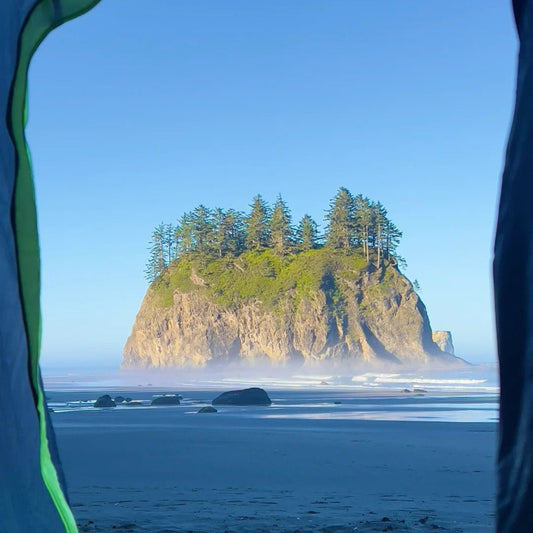 View from tent showing iconic Olympic Coast sea stack formations, illustrating the unique beach camping opportunities along the coastal section of the 6-day Olympic Grand Loop