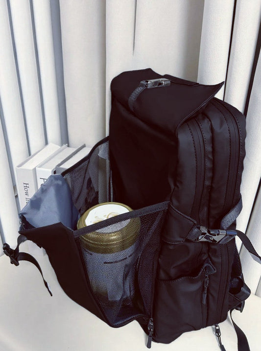 Black SAHD backpack showing multiple compartments, side mesh pockets, and organized storage for baby bottles, diapers, and dad's daily essentials