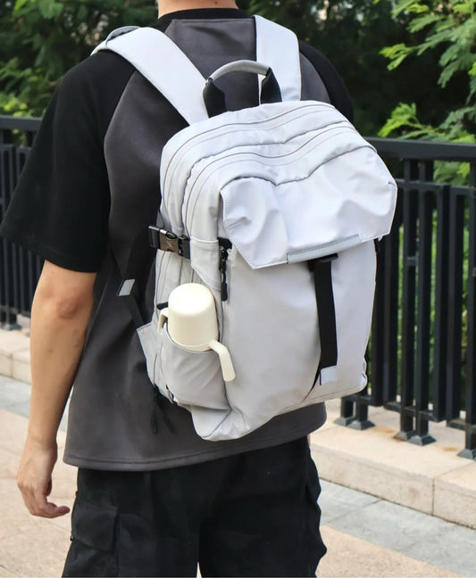 Man wearing stylish waterproof backpack with external bottle holder walking outdoors, demonstrating hands-free parenting convenience