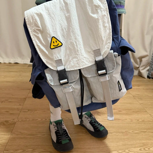 Teacher wearing 7706 lightweight backpack in school hallway with casual professional outfit
