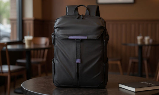 Black Backpackbeat lightweight expandable backpack on a café table, representing solo travel gear tested across city rides and early hikes.