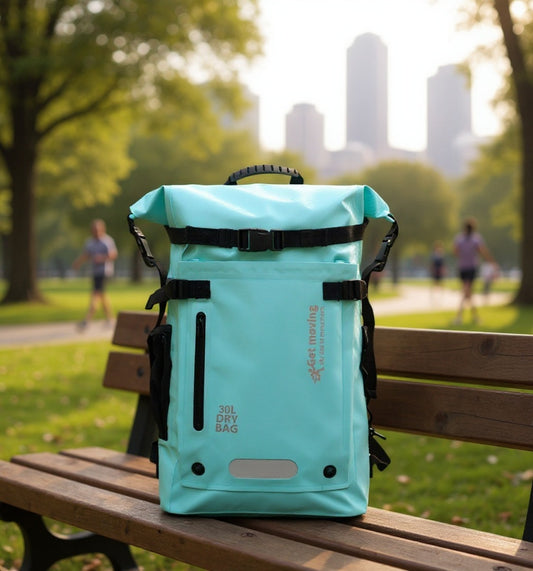 6603 waterproof backpack for travel 30L in turquoise positioned on park bench with city skyline, featuring "30L DRY BAG" marking for urban adventures