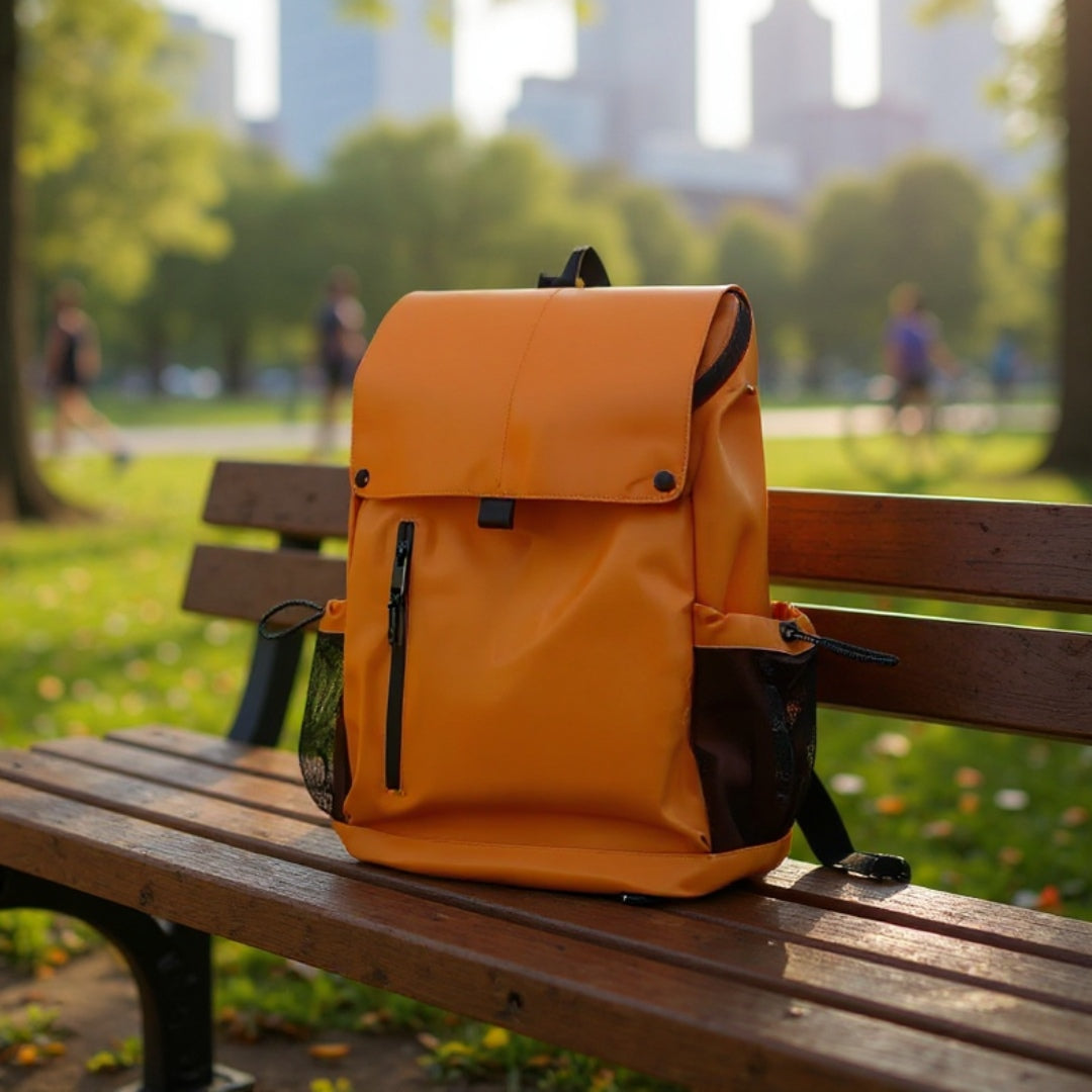 7709 stylish waterproof backpack 20L in bright orange placed on park bench with city skyline backdrop, perfect for urban commuting and outdoor relaxation