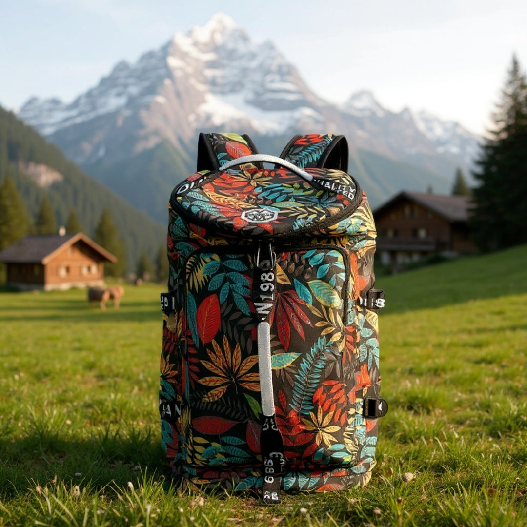 8801 stylish waterproof backpack 45L in tropical pattern positioned in Alpine meadow with mountain chalets, demonstrating outdoor travel versatility