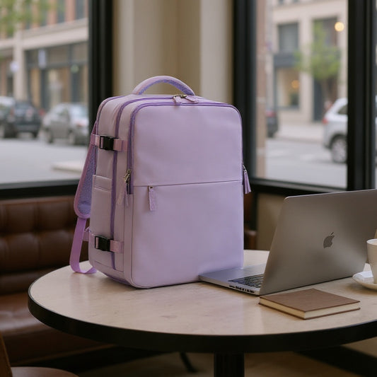 Purple 8802 travel backpack 35L positioned on cafe table next to MacBook laptop in urban setting, demonstrating professional business travel usage and compact design