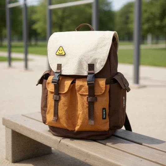 Backpackbeat 7706 brown multi-color lightweight waterproof backpack with earth tone design positioned on wooden bench at outdoor fitness area, showcasing urban active lifestyle with soft-focus exercise equipment and green trees in background