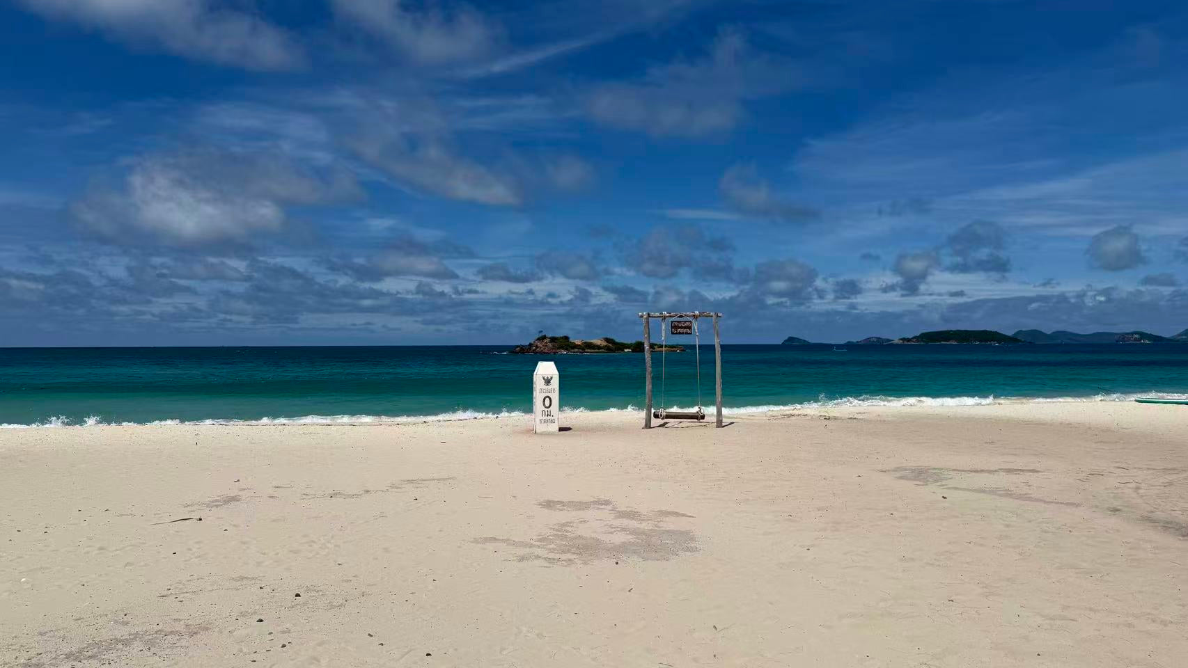 Waterproof backpack on beach near sea swing, ideal for travel and outdoor use