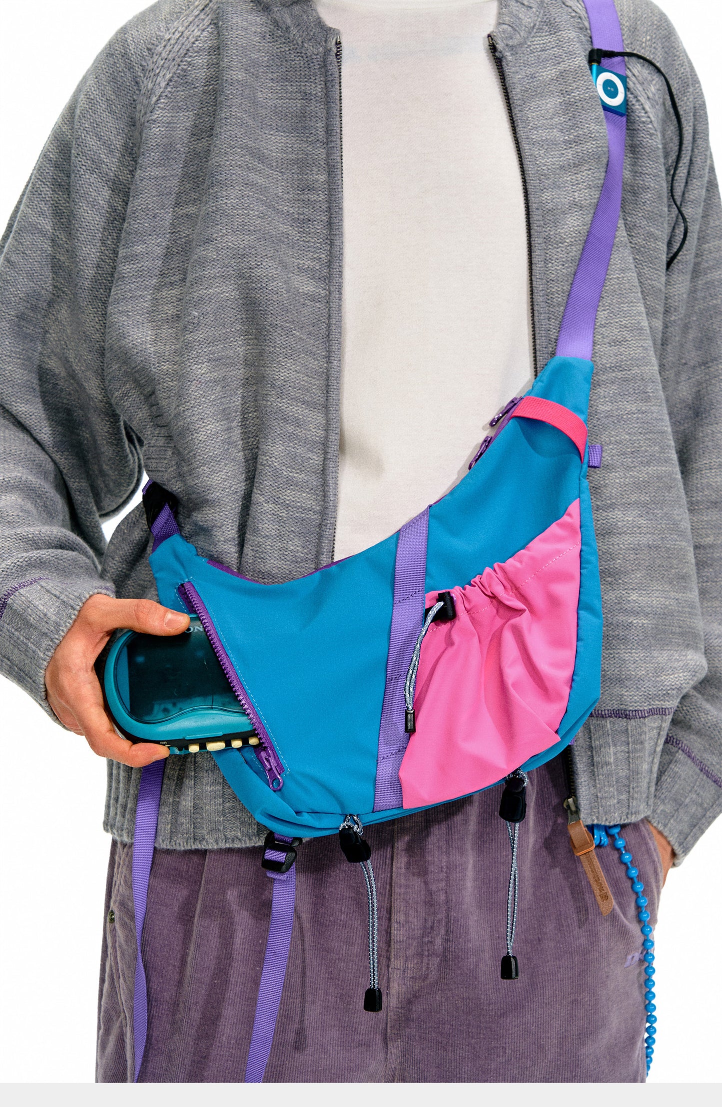 Model wearing the Backpackbeat 9901 crossbody bag, accessing front zipper pocket