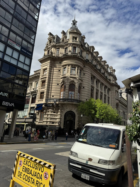 Ornate historic embassy building in Buenos Aires with pedestrians and cars in the foreground