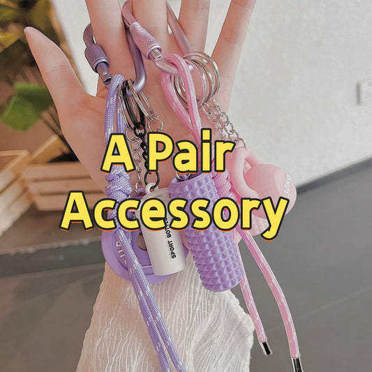 Pink and purple 001 fitness gear backpack accessories set pair displayed in hands showing detailed components including paracord straps, sport whistles, emergency tools, and carabiners designed for active lifestyle and outdoor safety