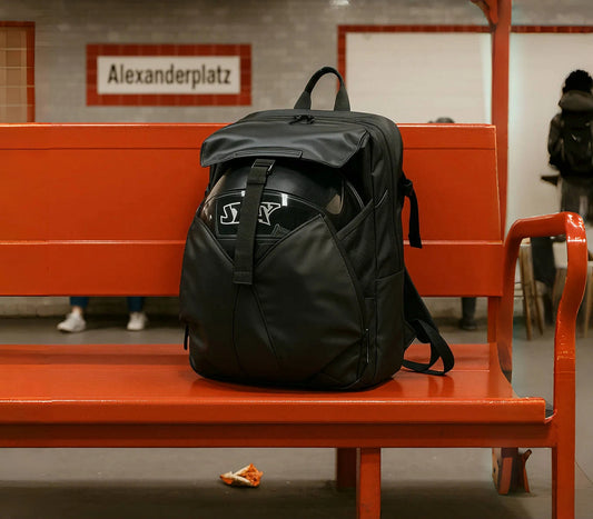 7700 waterproof backpack in black placed on a subway bench with red interior
