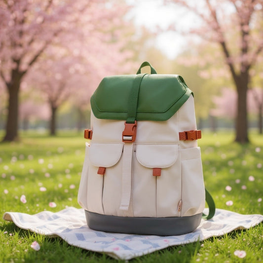 7708 stylish waterproof backpack positioned on picnic blanket under blooming cherry blossoms, showcasing outdoor leisure lifestyle and natural setting compatibility