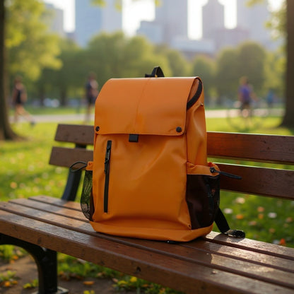 7709 stylish waterproof backpack 20L in bright orange placed on park bench with city skyline backdrop, perfect for urban commuting and outdoor relaxation