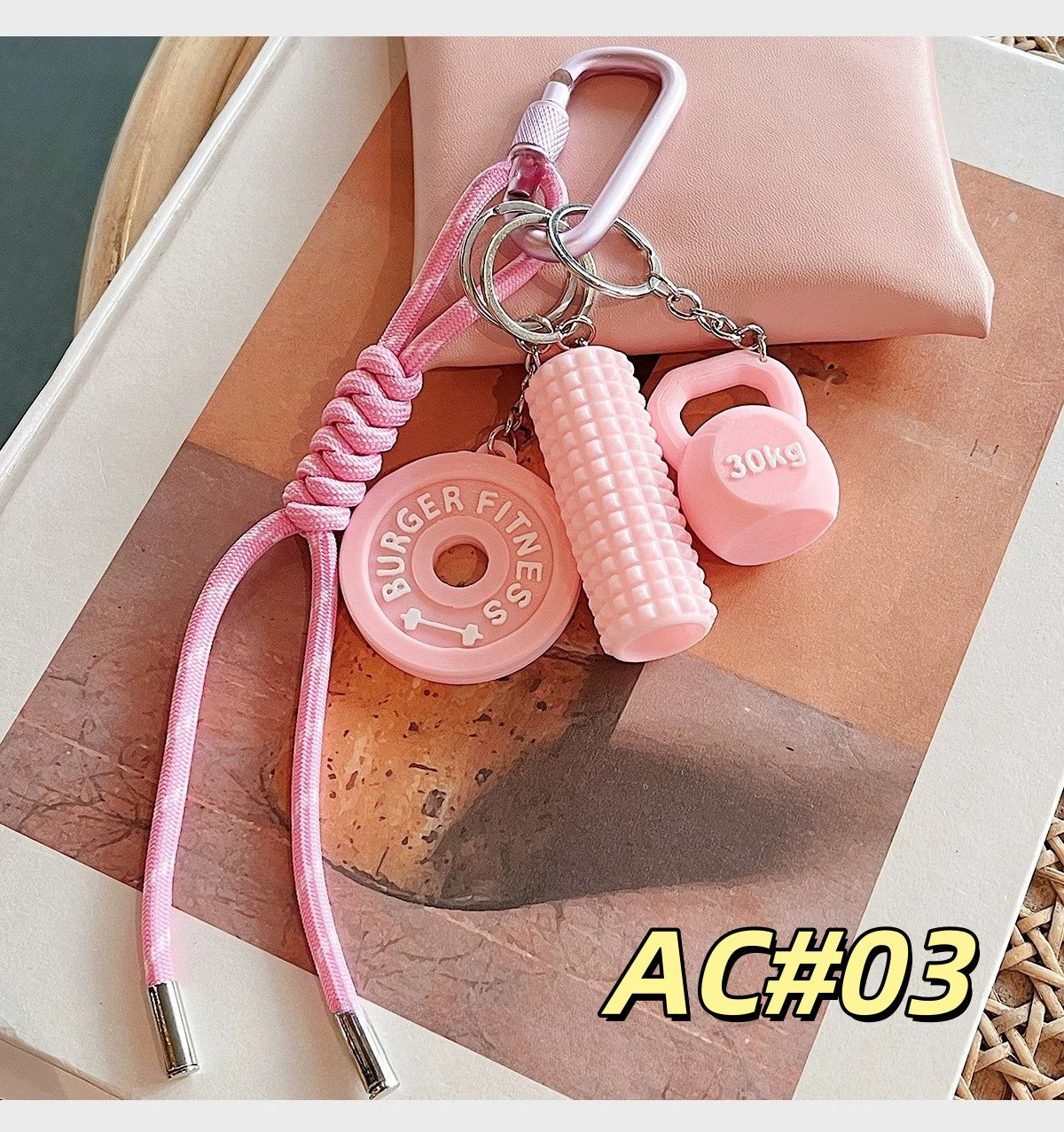 Pink fitness gear keychain AC#03 featuring BURGER FITNESS weight plate, 30kg dumbbell, and foam roller with braided cord and carabiner