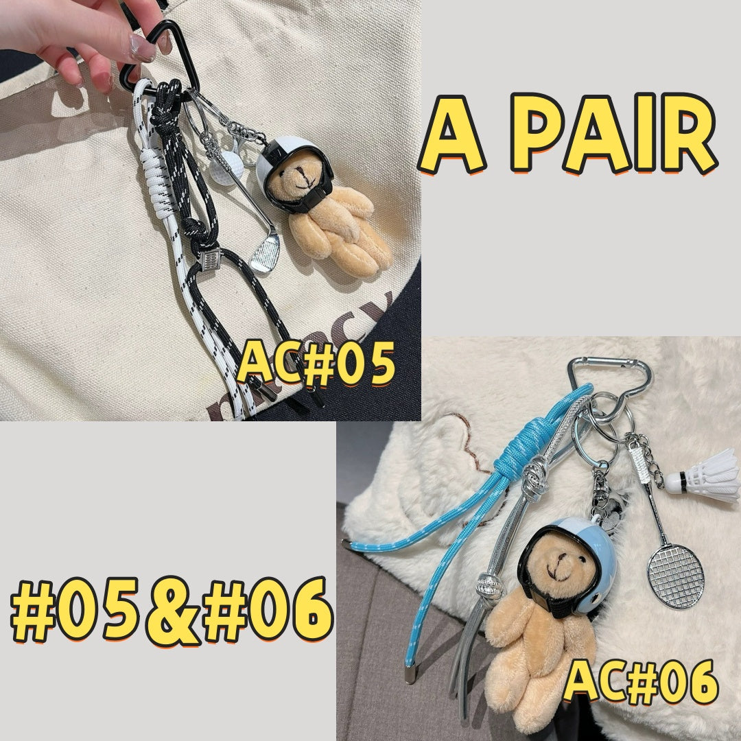 Cute fitness keychain pair AC#05 and AC#06 showing teddy bears with headphones in black/white and blue colors, plus tennis racket charm