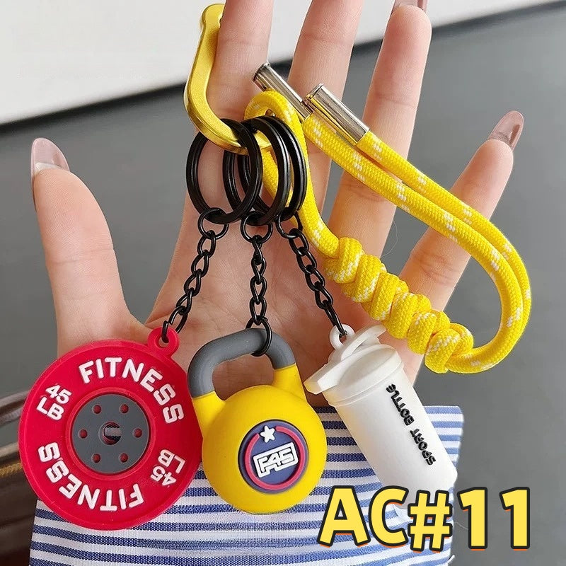 Yellow fitness gear keychain AC#11 featuring red FITNESS weight plate, 300kg yellow kettlebell, and Sport Bottle tag with braided cord