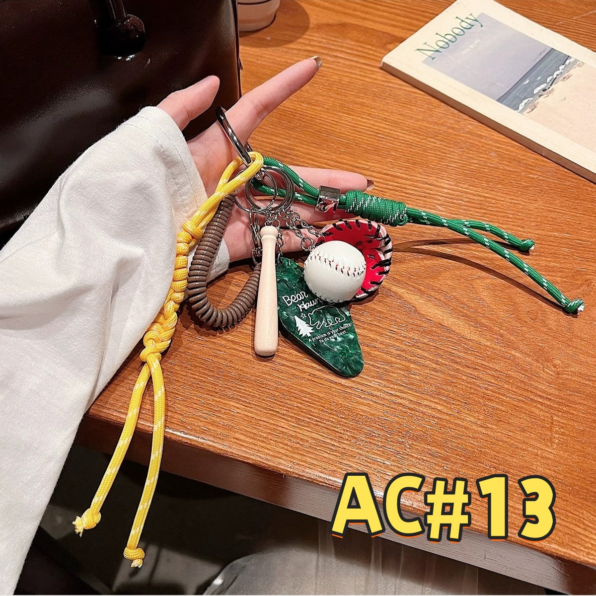 Baseball-themed sports keychain AC#13 featuring baseball glove, bat, white baseball, green braided cord with yellow accents and multiple chains