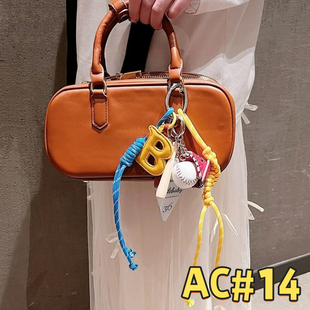 Blue baseball-themed keychain AC#14 featuring letter B charm, baseball glove, bat, white baseball, and Smilebaby motel card with braided cords