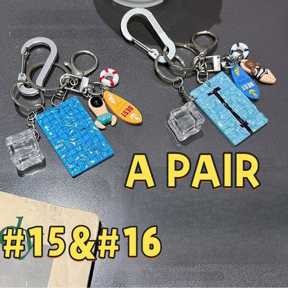 Swimming pool keychain pair AC#15 and AC#16 featuring blue mosaic tiles, swimmer figures, life rings, Best cards, and clear cube charms