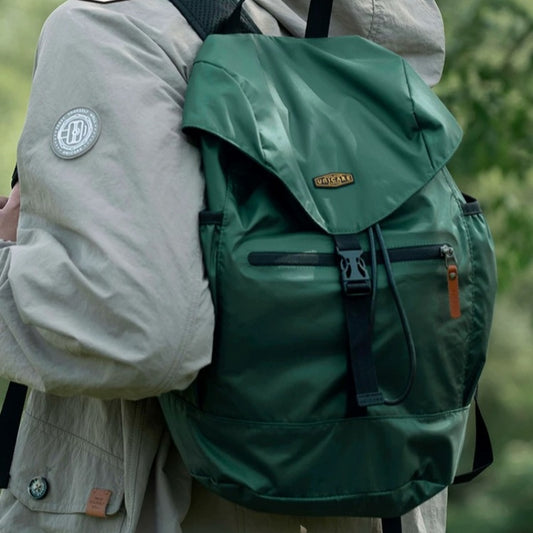 Person wearing green lightweight hiking backpack in natural outdoor setting showing real-world trail use