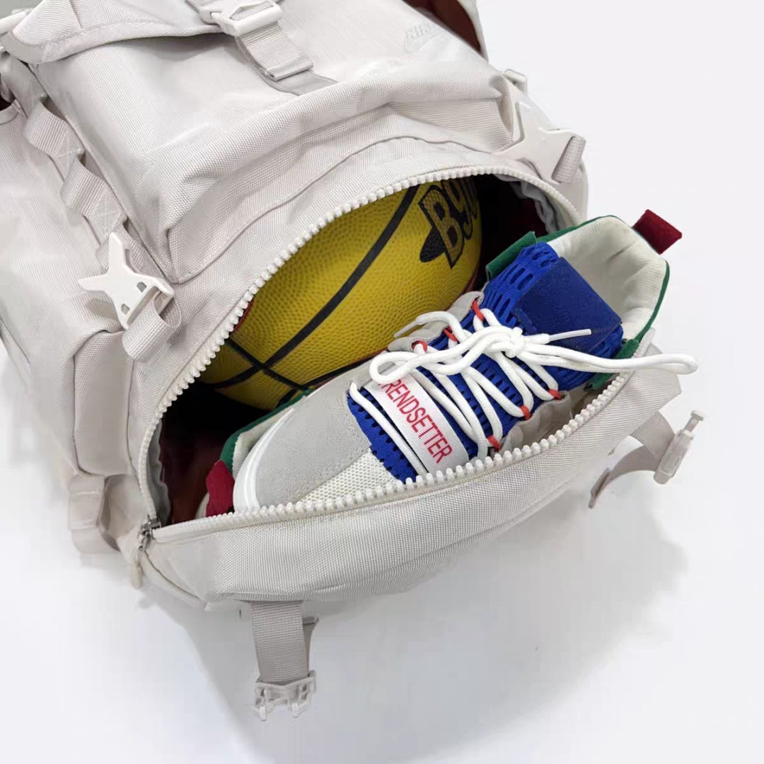 Bottom compartment of hiking backpack opened showing basketball and shoes storage capability
