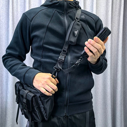 Model using the 1101 modular crossbody strap with an attached side pouch and phone, demonstrating multi-functional travel setup.
