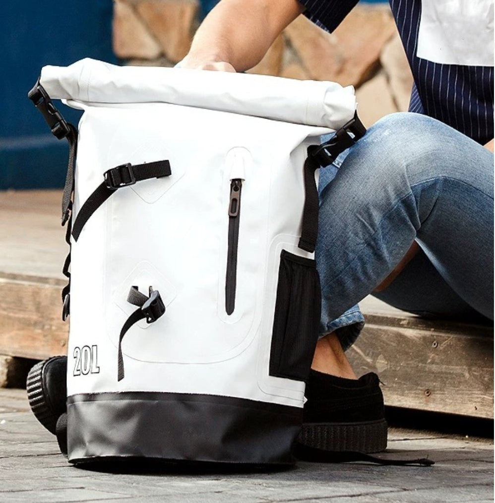 The BackpackBeat 6601 completely waterproof backpack 20L placed on the ground near a seated person, captured in daily use.