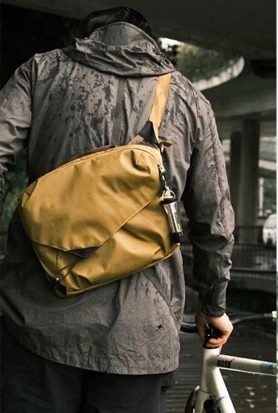 Backpackbeat 9900 waterproof crossbody bag worn outdoors by cyclist on a rainy day