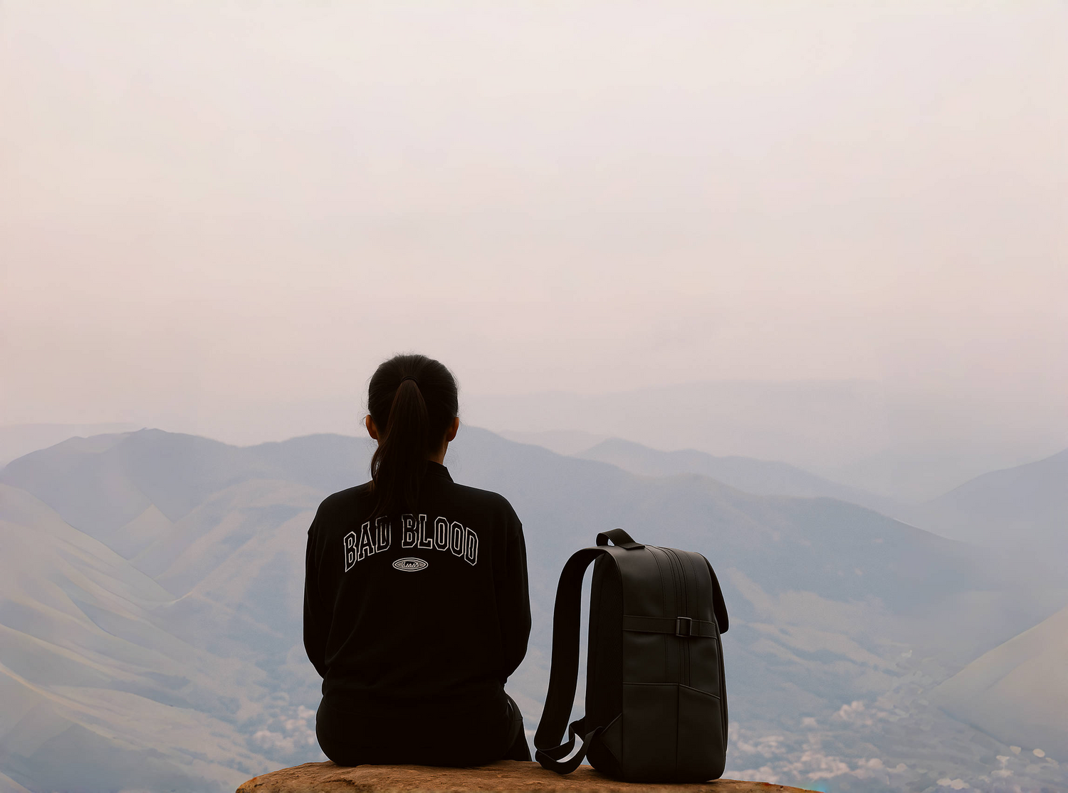 A woman takes a quiet break on a mountaintop with the BackpackBeat 8808 Extend Waterproof Backpack by her side